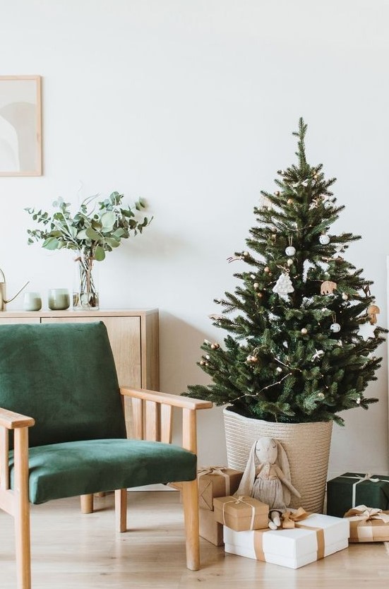 a modern Nordic Christmas tree in a basket, with lights and just several white Christmas ornaments is a lovely idea for your modern space