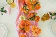 36 a pink and orange Thanksgiving table setting with a pink runner and orange blooms, orange and pink glasses and pink napkins