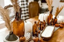 36 boho meets rustic Thanksgiving decor with dark bottles with grasses, mini faux pumpkins and large white ones, a large candle