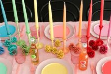 38 a rainbow Thanksgiving tablescape with bright plates and candles, bold pinecones and pink cutlery is very unusual