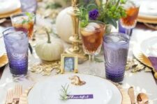 39 a refined gold and purple Thanksgiving tablescape with gold cutlery, chargers and candlesticks, white pumpkins, greenery, purple glasses and napkins
