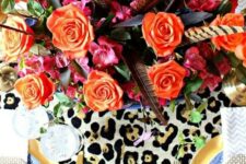 41 a super bold Thanksgiving tablescape with blue and gold plates, a leopard and hot pink table runner, orange blooms and feathers