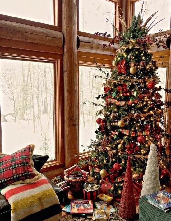 a vintage Christmas tree with lights, red, gold and green ornaments, twigs, berries and herbs