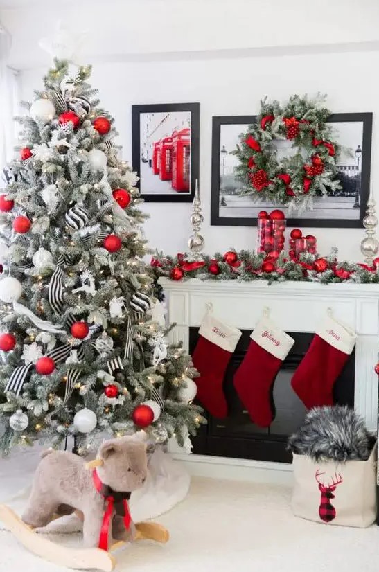 a flocked Christmas tree with red and white ornaments, with lights and black and white striped ribbons