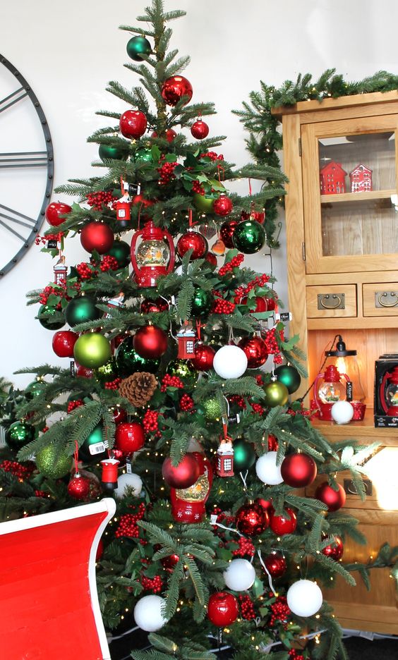 a fantastic Christmas tree decorated with red, green and white ornaments, lights, pinecones and berries