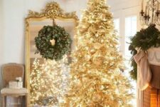 52 a gold pre-lit Christmas tree with white ornaments and a faux fur skirt is a super glam and shiny idea for the holidays