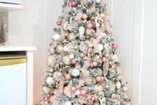 54 a flocked Christmas tree done with ribbon, pink, blush, white and gold ornaments, a pink star on top and some lights