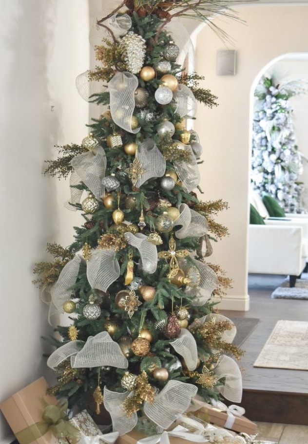 a glam Christmas tree with silver, gold, grey, brown ornaments, gilded branches, pinecones, neutral ribbons and branches is a unique idea