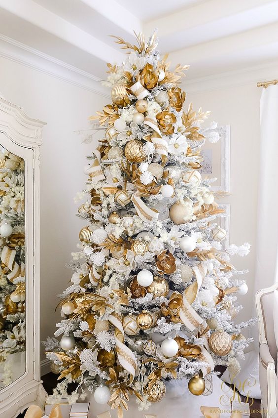 a super glam white Christmas tree with white, silver and gold ornaments, gold leaves and beads is a gorgeous idea