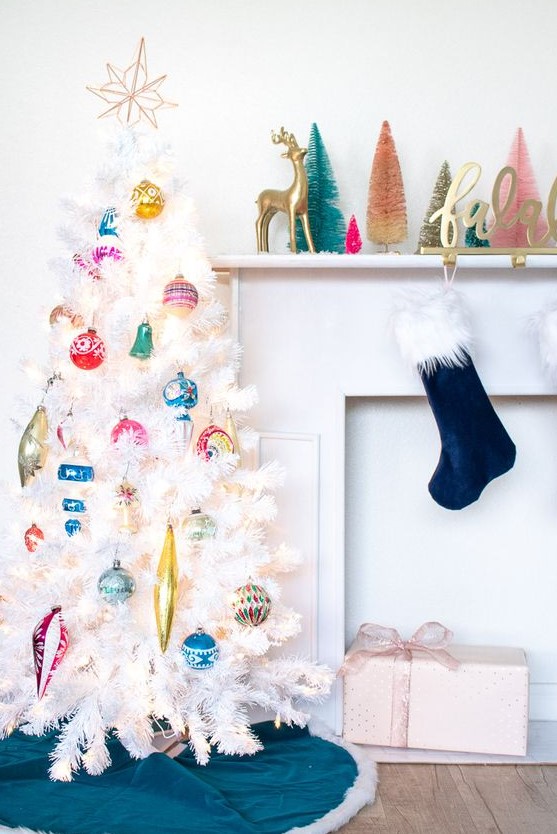 a white Christmas tree decorated with colorful vintage Christmas ornaments and a topper is a stylish and chic idea