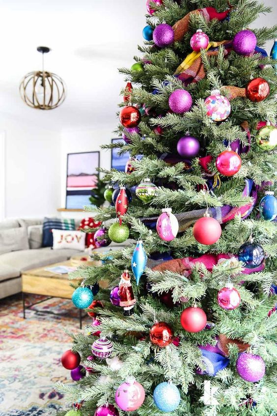 a super bold and chic modern Christmas tree decorated with colorful ornaments of various shapes