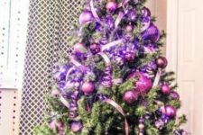 a Christmas tree with purple and hot pink ornaments, ribbons and lights is a beautiful idea for a colorful Christmas space