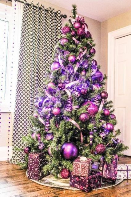 a Christmas tree with purple and hot pink ornaments, ribbons and lights is a beautiful idea for a colorful Christmas space