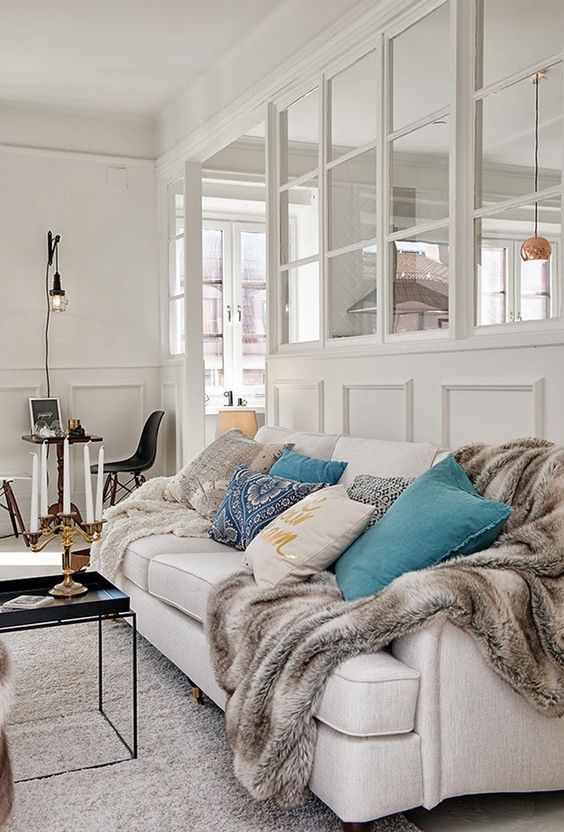 a beautiful Scandinavian living room in neutrals, with an internal window that connects the living room and kitchen