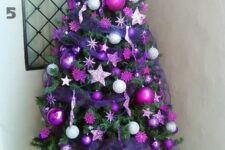 a bright Christmas tree with hot pink and purple ornaments, purple ribbons and stars is amazing for colorful spaces