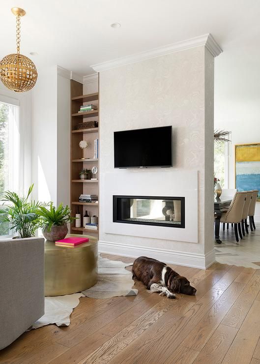 a built-in double-sided fireplace gives interest and a cozy feel to both the living room and the dining zone