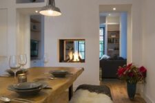 a built-in double-sided fireplace gives light and warmth to the dining and living room and separates them