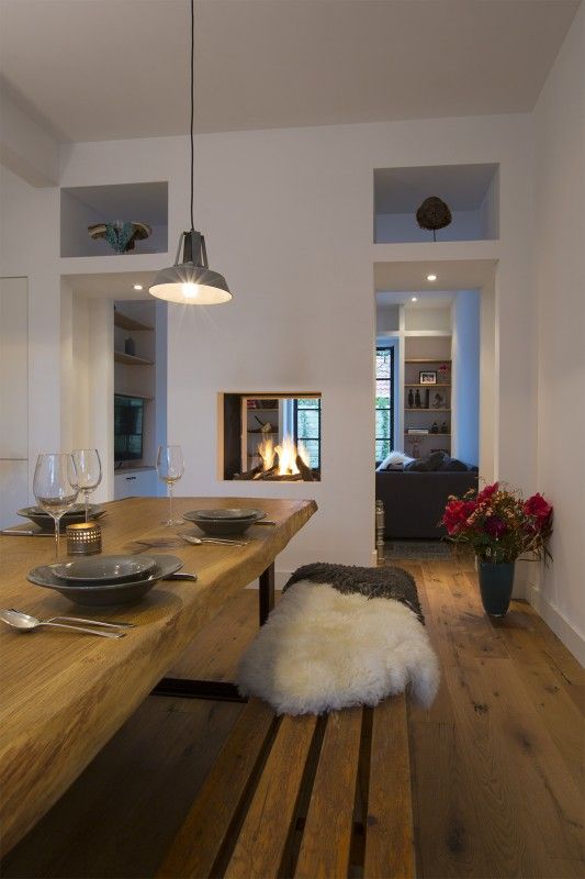 a built-in double-sided fireplace gives light and warmth to the dining and living room and separates them