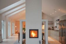 a built-in fireplace with firewood storage gives a lovely touch to both the living room and the kitchen