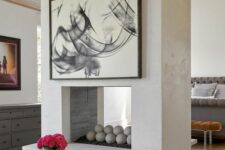 a cocnrete double-sided fireplace gives warmth and coziness to both bedroom and living room and separates the spaces