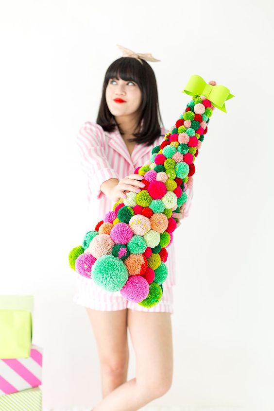 a colorful pompom cone-shaped Christmas tree topped with a bold bow is an amazing idea for bright holiday decor