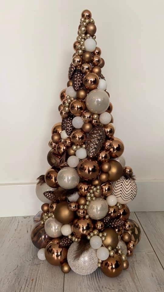 a cone-shaped Christmas tree completely covered with brown, beige, pear and white ornaments of various shapes