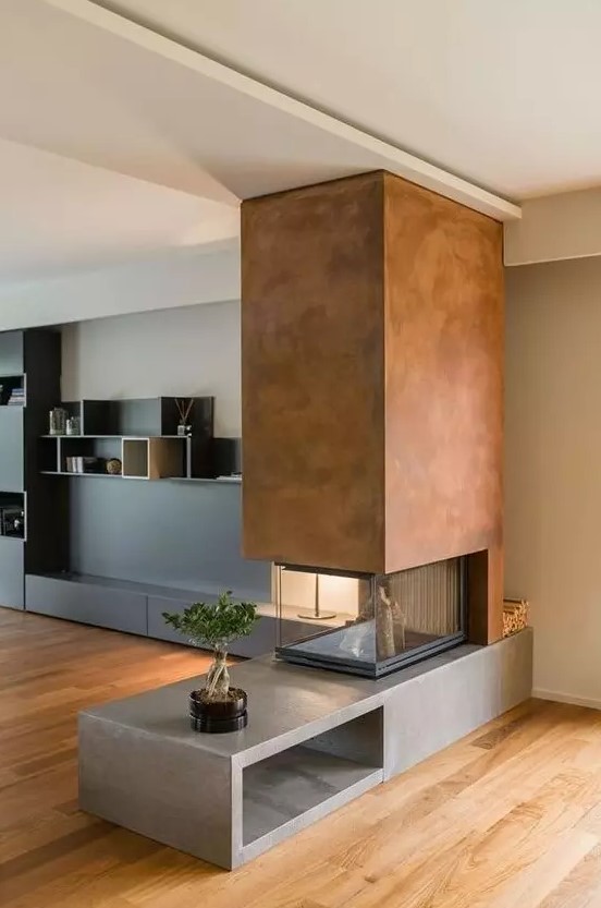 a contemporary double sided  fireplace with a concrete base, a metal hood and a glass cover looks contrasting and very bold