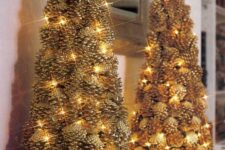 a couple of gilded pinecone Christmas trees decorated with lights look very festive and interesting