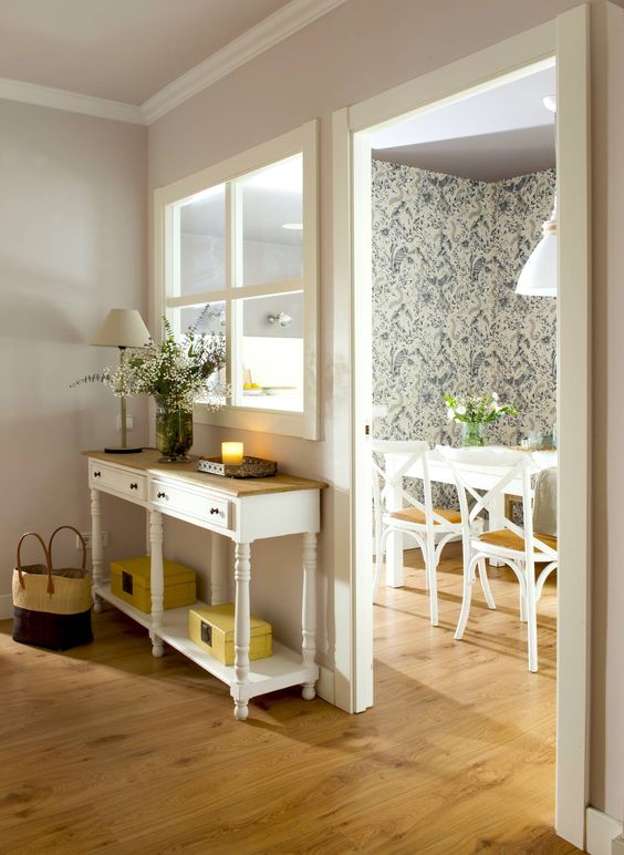 a cozy cottage-inspired space lets some natural light from the dining room to the entryway through a small window