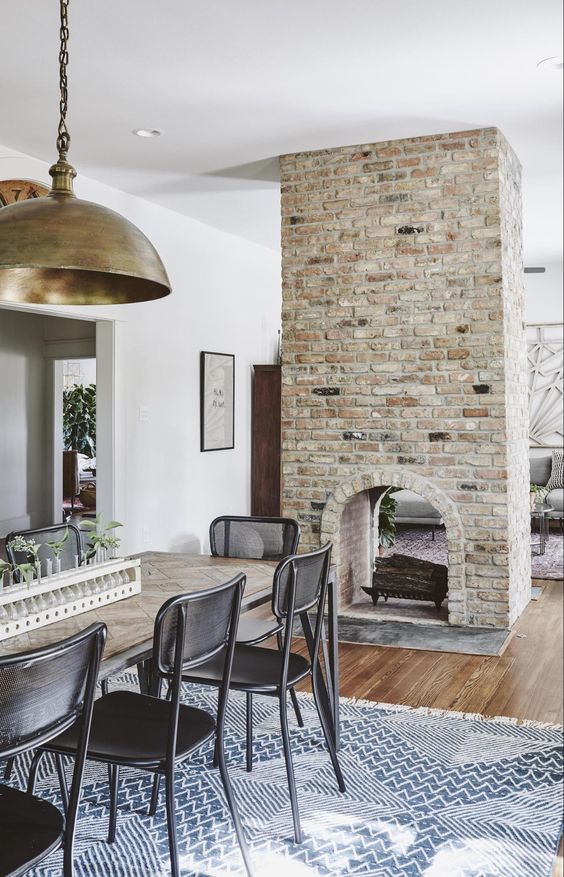 a double sided arched brick fireplace gives a cozy feel to both the dining room and the living room