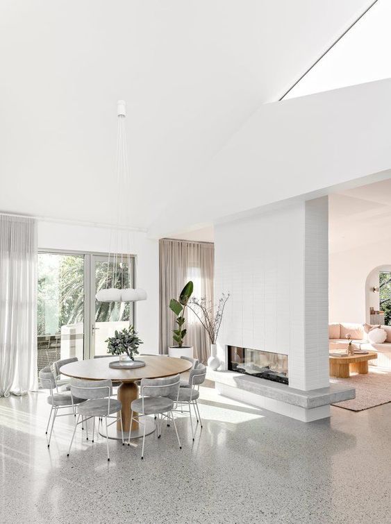 a double-sided fireplace clad with brick is a pretty and cozy space divider for the dining-living room zone