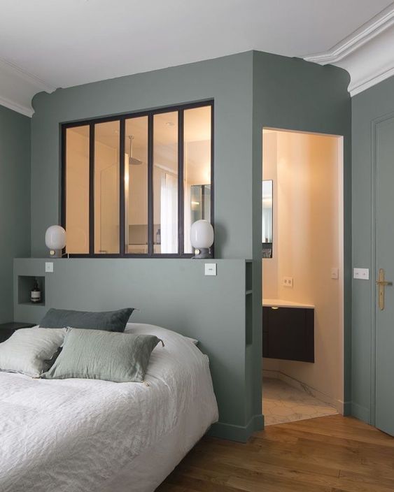 a green Scandinavian bedroom with a small master bedroom and a window that connects the two spaces and lets light inside