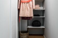 a grey narrow closet with open shelves and railing, a basket for various stuff is a small and laconic space to store your clothes