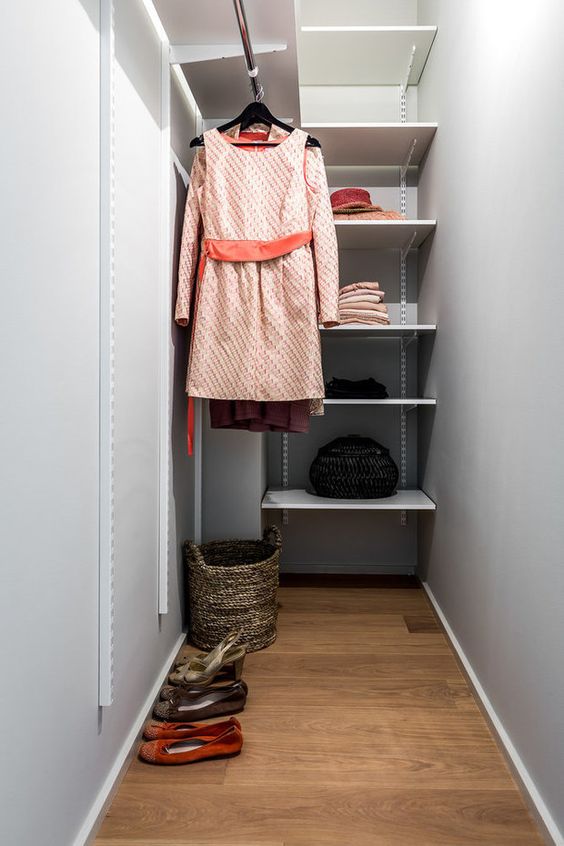 a grey narrow closet with open shelves and railing, a basket for various stuff is a small and laconic space to store your clothes