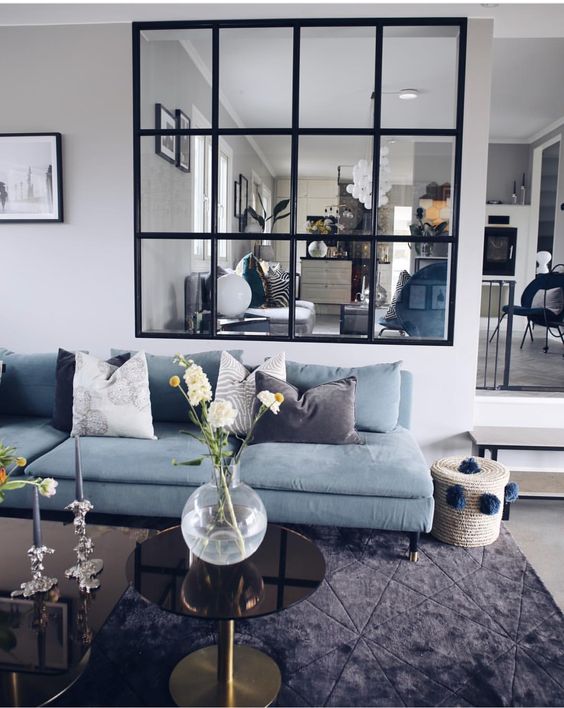 a living room and a dining room connected to each other through a large black frame French window look very airy and light-filled