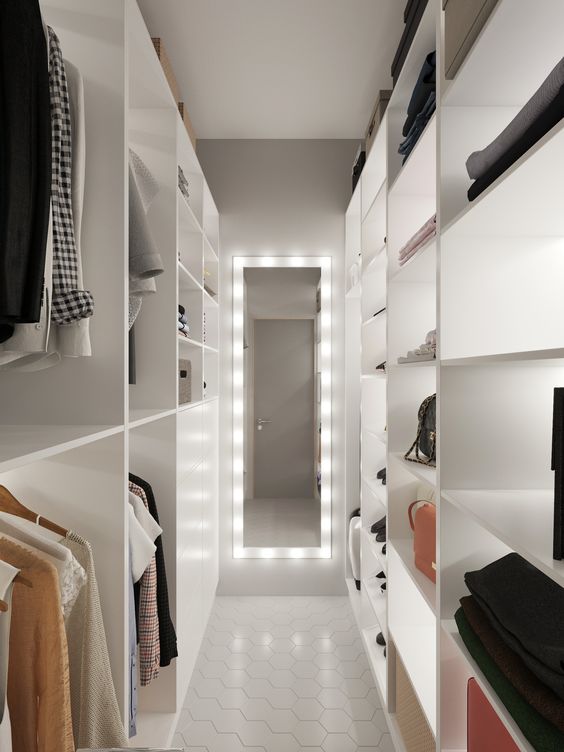 a minimalist white closet with shelves and open storage compartments, with a lit up mirror and lit up shelves is cool and features a lot of space