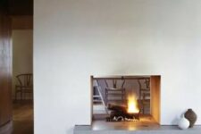 a modern white double-sided fireplace with a concrete stand is a cozying up and chic idea for a modern space