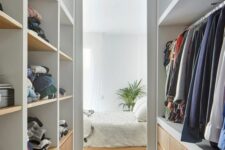 a narrow walk-in closet with open storage compartments and drawers is a lovely space with built-in lights