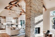 a neutral farmhouse home with a built-in fireplace clad with brick that becomes a centerpiece of the living room and foyer