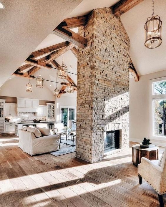 a neutral farmhouse home with a built-in fireplace clad with brick that becomes a centerpiece of the living room and foyer
