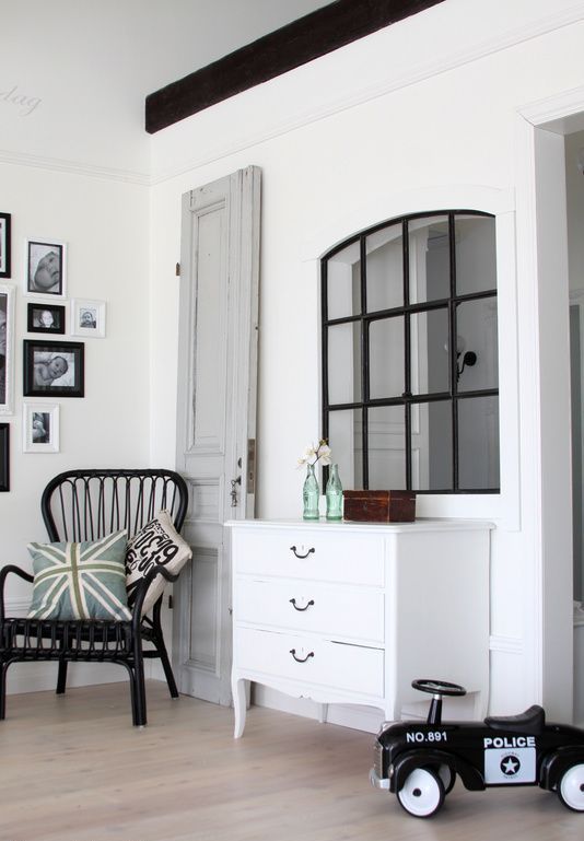 a pretty arched window connects the living room and the next space giving it more light and giving a refined touch to the interior