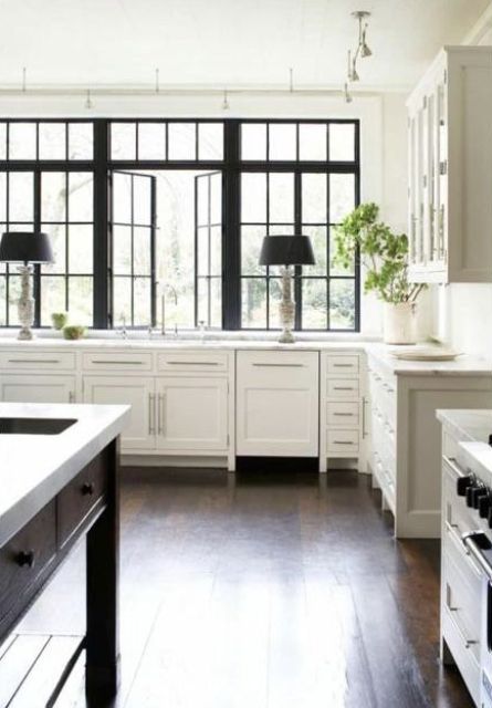 a refined vintage kitchen with white cabinetry, a large black casement window with French panes that contrasts the space