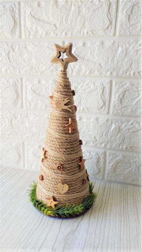 a rope Christmas tree decorated with wooden stars, buttons, birds and topped with a wooden star topper
