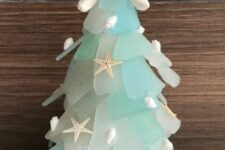 a seaglass cone Christmas tree decorated with little shells and starfish and topped with a starfish is a great decoration for a coastal Christmas space