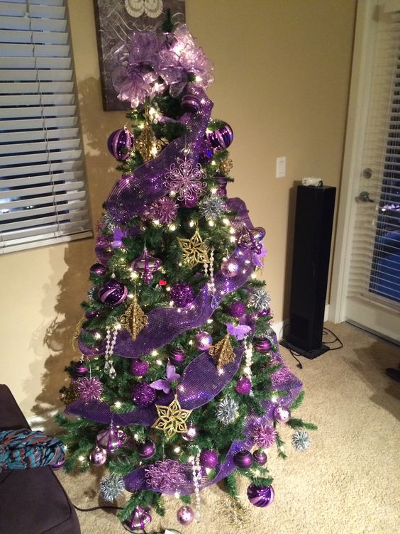 a shiny Christmas tree with purple ribbons and ornaments, gold stars and large ribbon bows plus lights is a cool idea