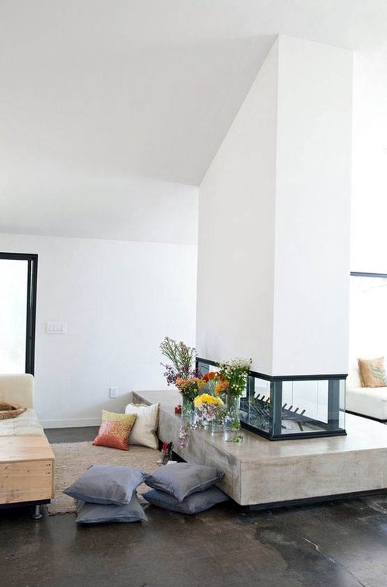 a stylish white double sided fireplace with a glass part and a concrete one is a chic idea for a contemporary home