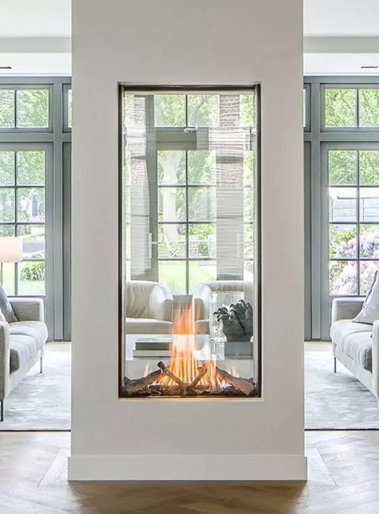 a two sided fireplace with glass will provide two spaces with a beautiful fire look and with coziness and chic
