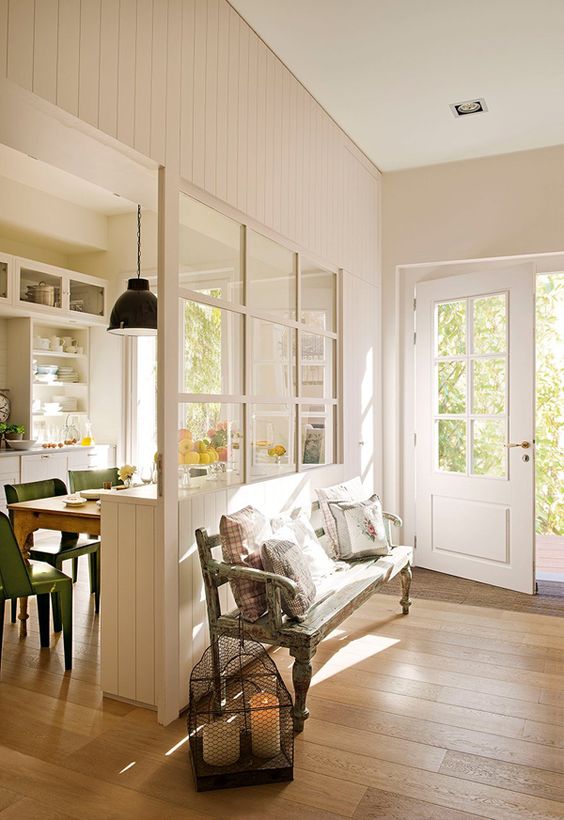 a welcoming and light-filled entryway with a window to the dining room to connect the spaces and make them look bigger