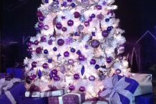 a stylish white Chrsitmas tree with purple ornaments