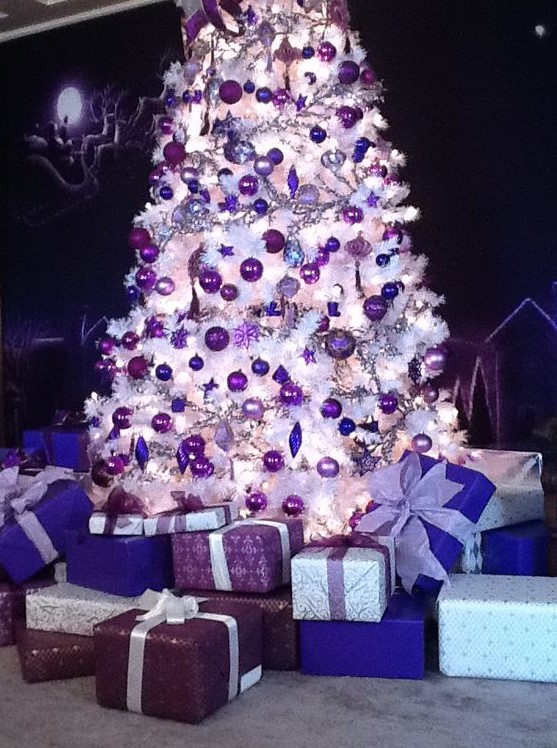 a white Christmas tree with deep purple, lilac and bold purple ornaments of various shapes that looks amazing
